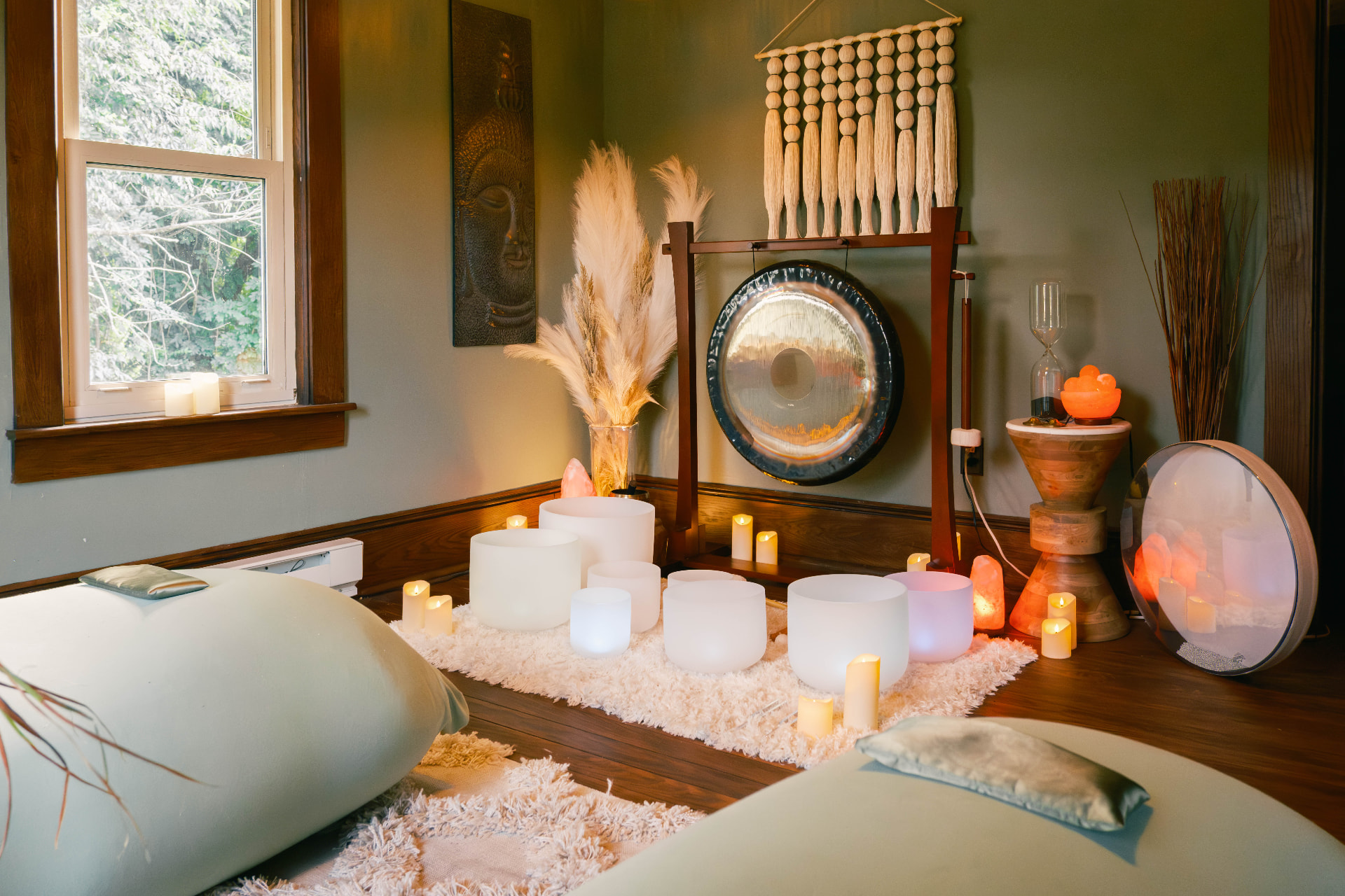 The Sound & Soul studio with cushioned mats, gong, crystal bowls, salt lamps, and candlelight