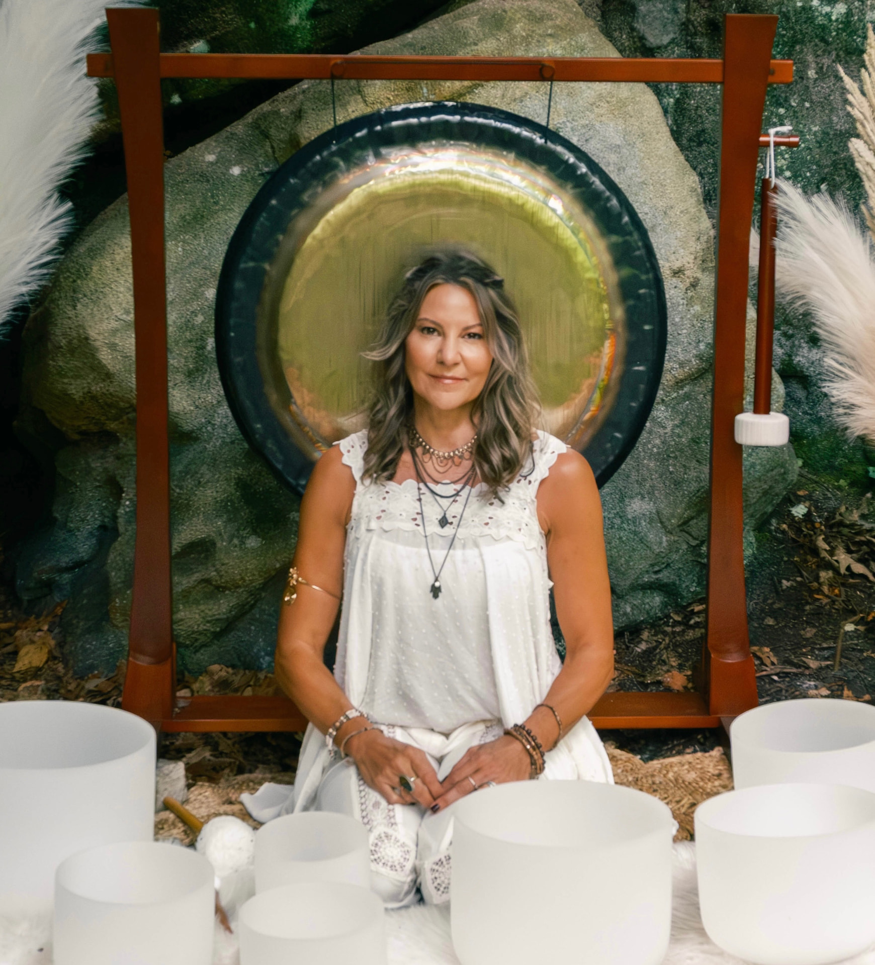 Tanya Schwinabart, certified sound practitioner, seated beside a gong and singing bowls